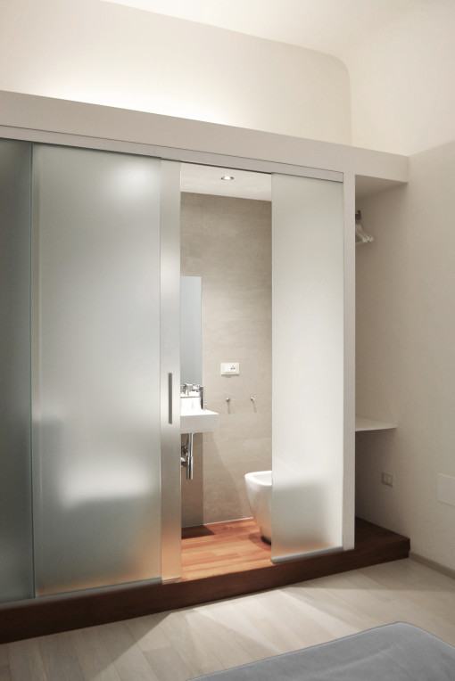 Nella camera Tubox un volume architettonico multifunzione ospita bagno, doccia e armadio. 