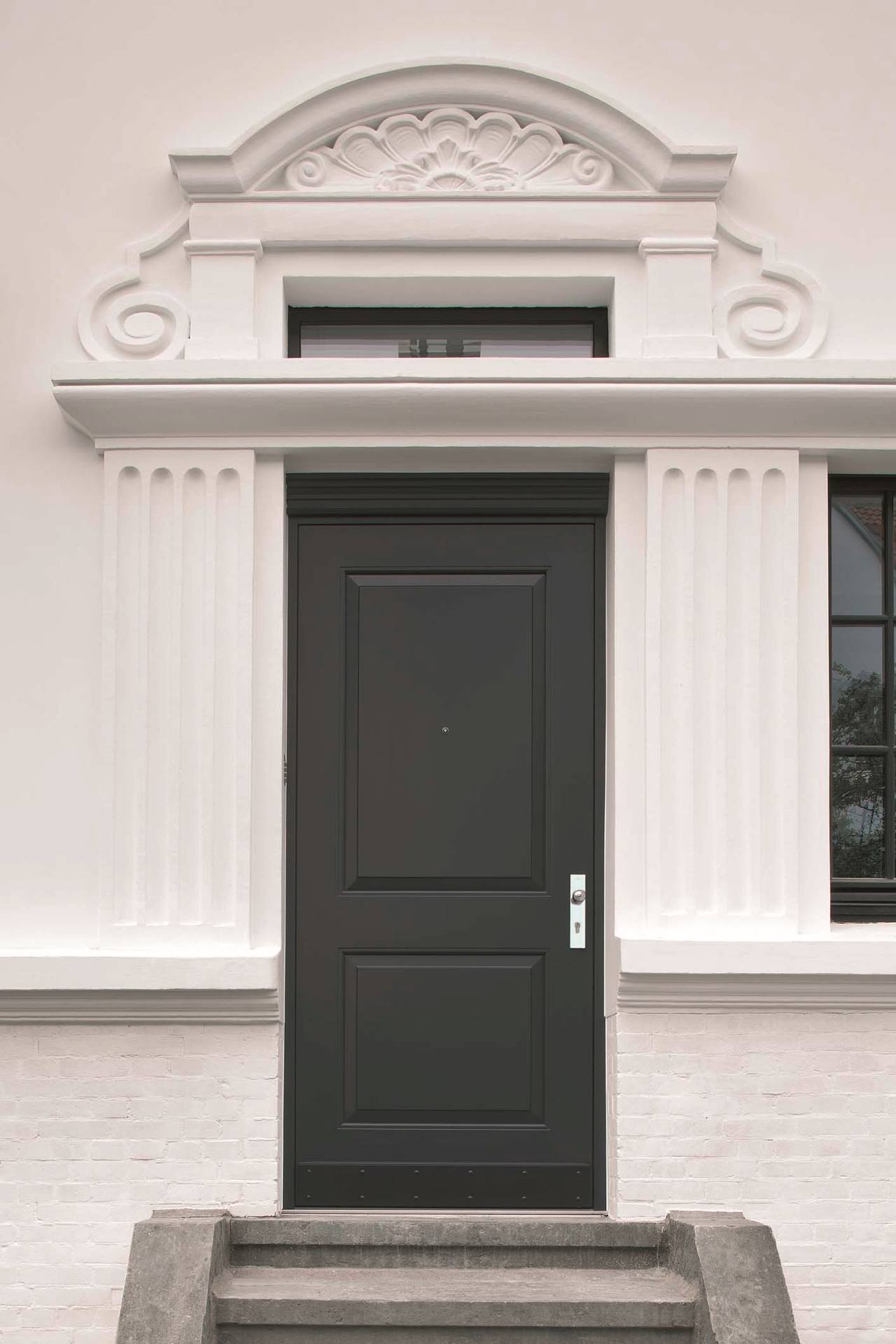 Il design e la manifattura della nuova porta realizzata dal serramentista, con la cerniera a scomparsa totale, si armonizzano alla perfezione con lo stile della villa storica.