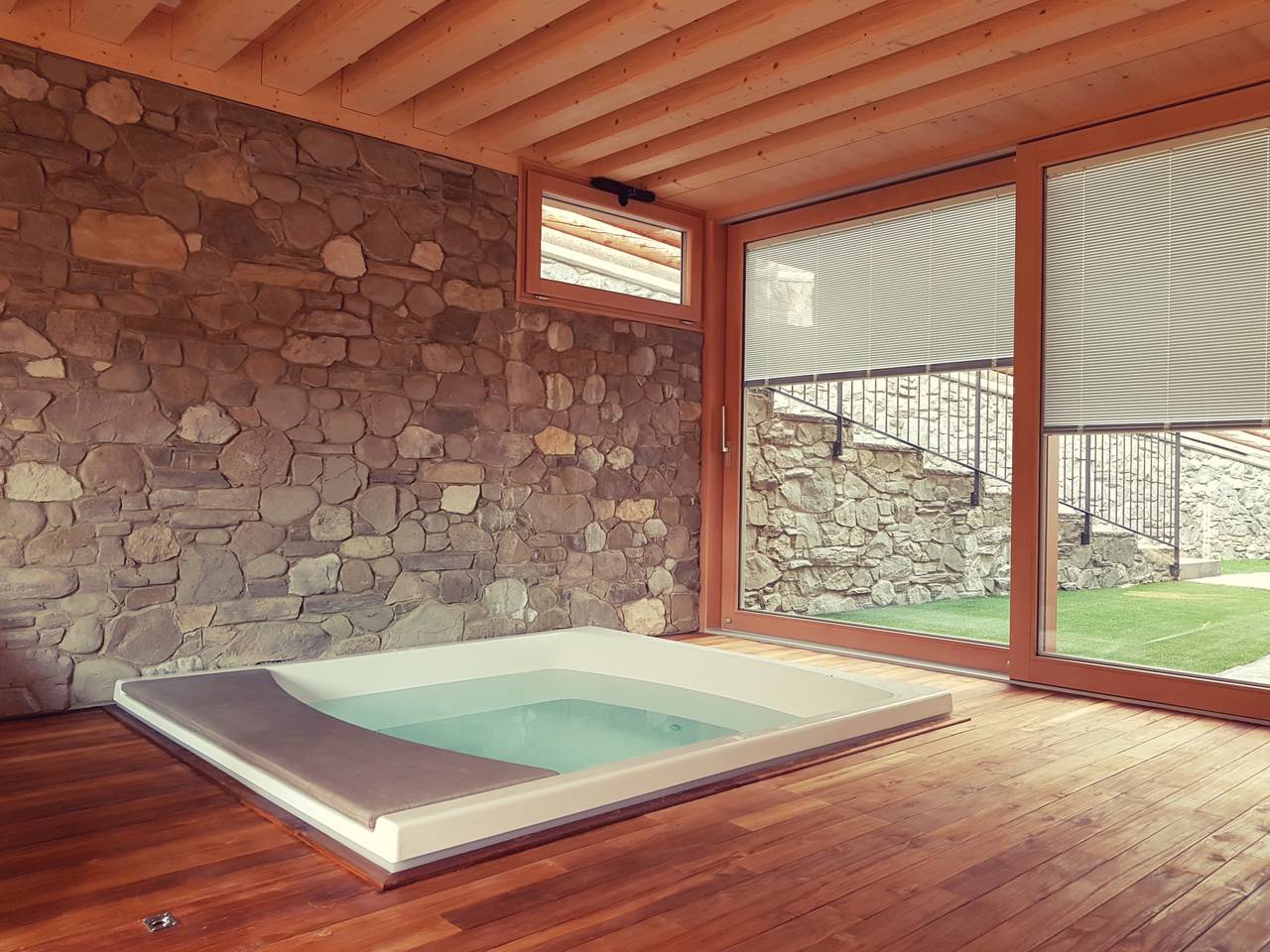 Zona SPA, con vista sul giardino, che ospita una mini piscina idromassaggio, una sauna e una zona relax